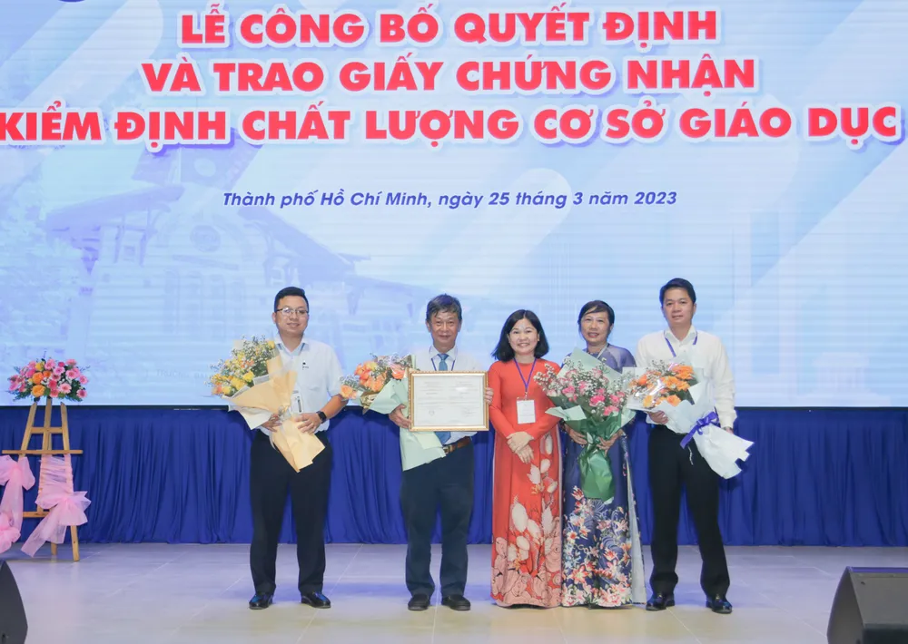 Ban lãnh đạo Trường ĐH Sài Gòn nhận giấy chứng nhận và hoa từ đại diện Trung tâm Kiểm định chất lượng giáo dục (ĐH Quốc gia TP.HCM). Ảnh: NT