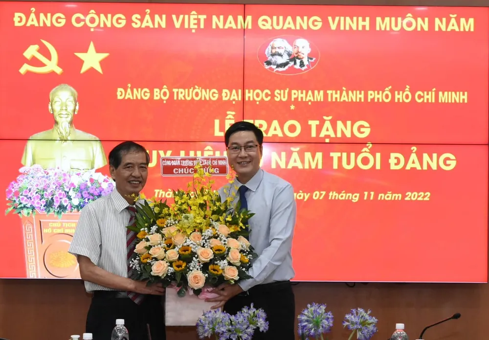 Phó giáo sư Bùi Mạnh Nhị (bên trái) tại buổi lễ nhận huy hiệu 30 năm tuổi Đảng do Trường ĐH Sư phạm TP.HCM trao tặng cuối năm 2022 vừa qua. Ảnh: NT