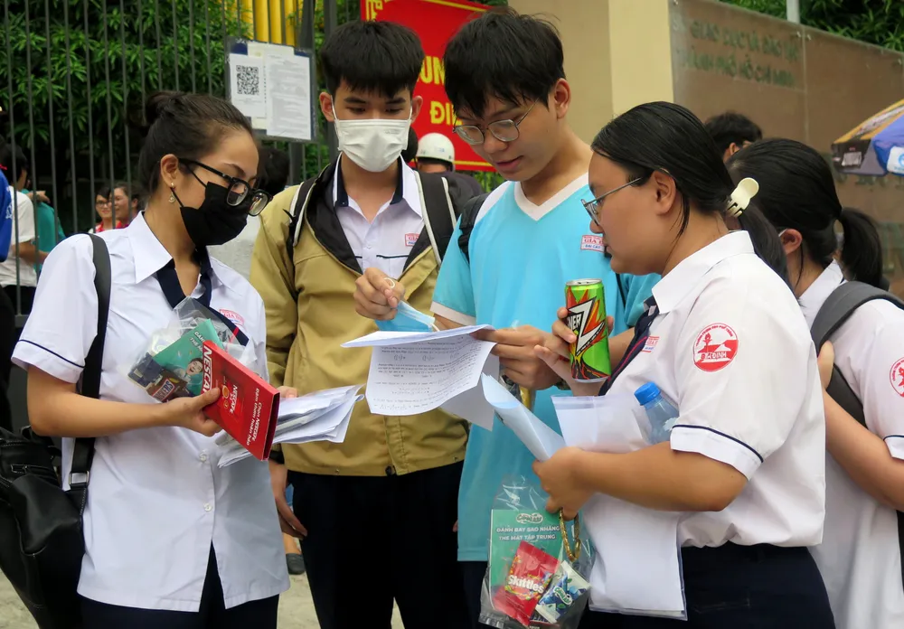 Thí sinh trao đổi bài ở kỳ thi tốt nghiệp THPT năm 2024 tại TP.HCM. Ảnh: P.ANH Điểm chuẩn xét học bạ năm 2024