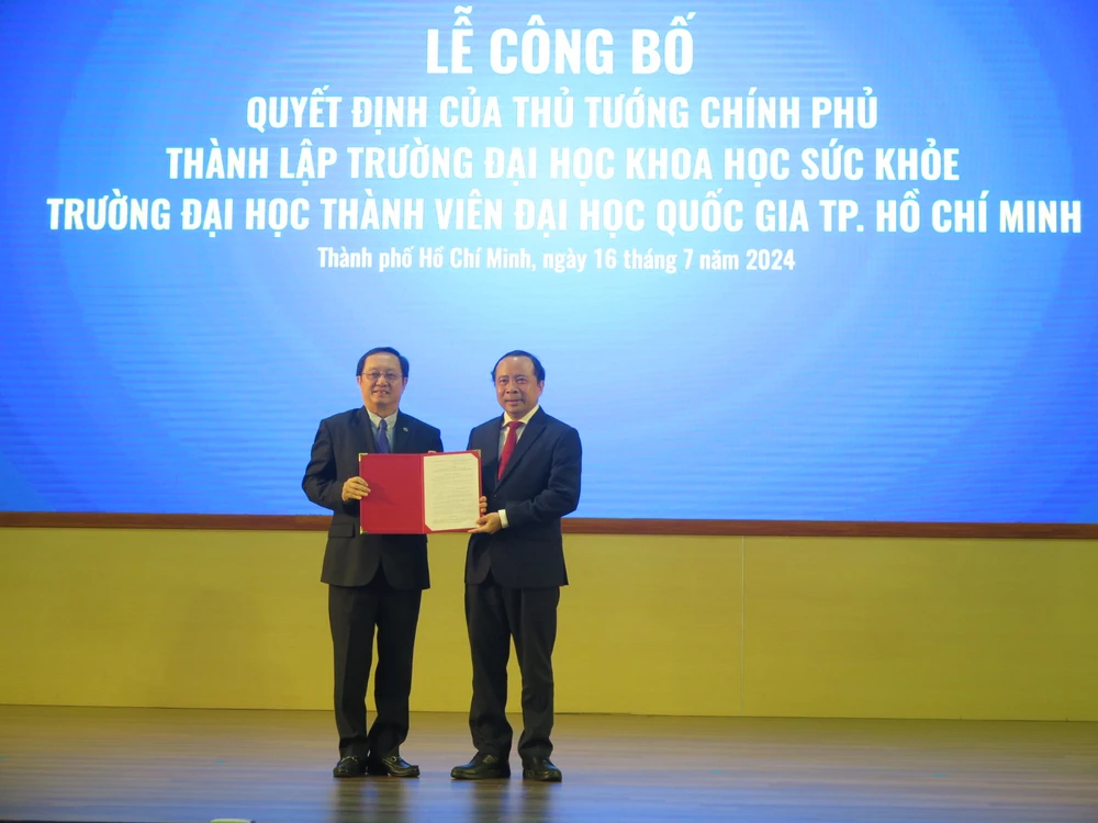 Bộ trưởng Huỳnh Thành Đạt (bìa trái) trao quyết định thành lập Trường ĐH Khoa học Sức khỏe cho PGS.TS Vũ Hải Quân - Giám đốc ĐH Quốc gia TP.HCM. Ảnh: P.A ĐH Quốc Gia TP.HCM