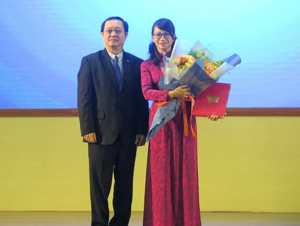 Bộ trưởng Huỳnh Thành Đạt trao quyết định bổ nhiệm và hoa cho GS.TS Nguyễn Thị Thanh Mai. Ảnh: PA ĐH Quốc gia TP.HCM bổ nhiệm nhân sự mới