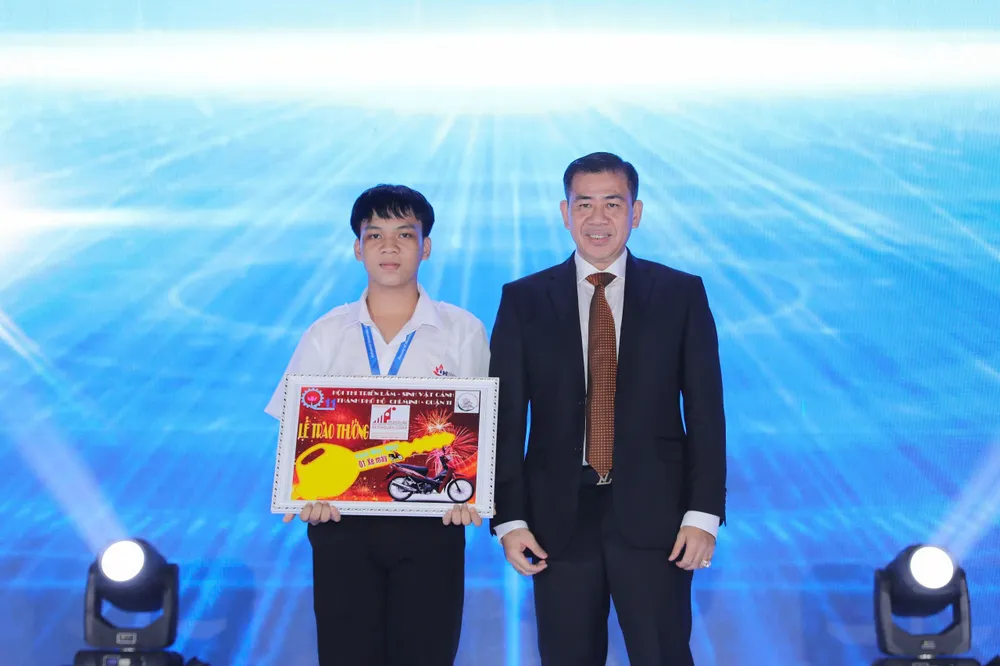 Em Hồ Thanh Sơn nhận thưởng chiếc xe máy do Hiệu trưởng Phan Hồng Hải trao tặng bằng tiền cá nhân. truong-dh-cong-nghiep-tphcm-khai-giang (2).jpg