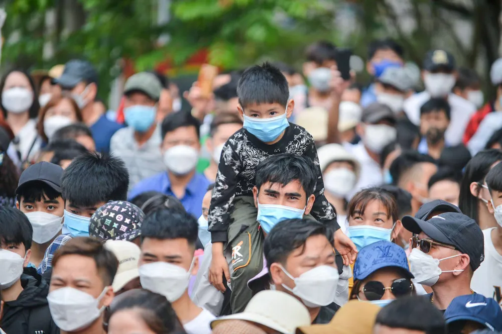 Trẻ nhỏ được phụ huynh cho ngồi lên vai để để giảm bớt sự ngột ngạt giữa dòng người đông đúc.