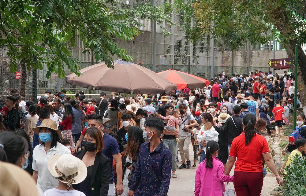 Gần trưa, dòng người tiếp tục đổ về khiến công viên trở nên đông nghịt, quá tải. Nhiều phụ huynh phải vội vã bồng con tránh nắng.