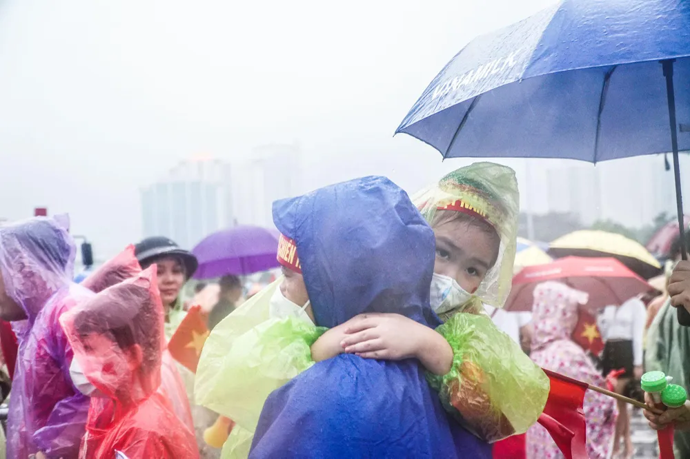 Nhiều bậc phụ huynh đưa cả con nhỏ vào sân dù trời mưa khá nặng hạt.