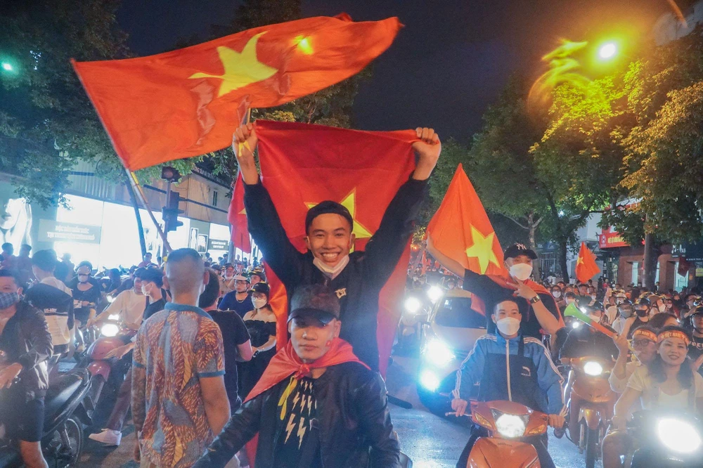 Nhiều cổ động viên phấn khích đưa cao lá cờ Tổ quốc như một niềm tự hào.