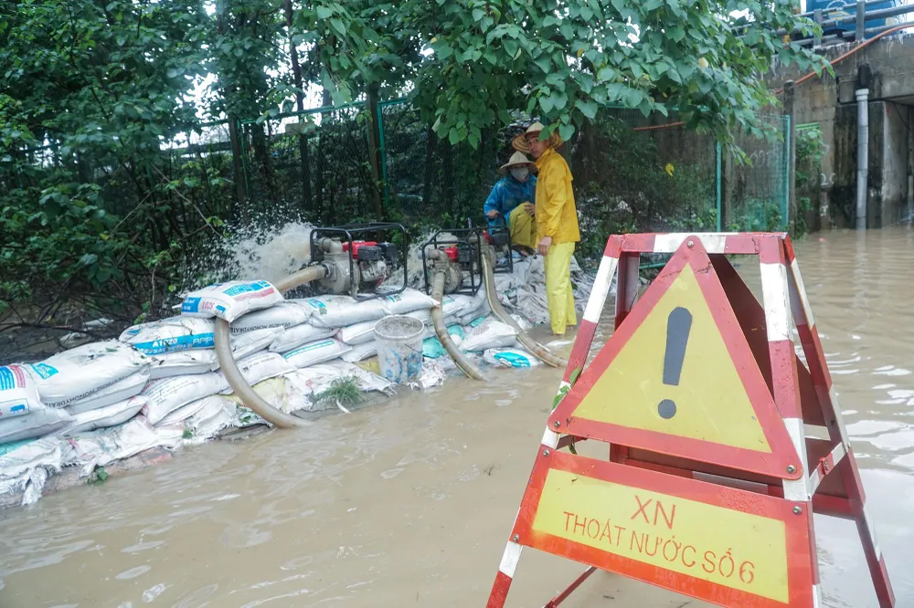 Hơn 10 giờ sáng cùng ngày, công nhân vẫn đang dùng máy bơm công suất lớn để xả nước với mục đích rút cạn nước ngập trên đoạn đường này.