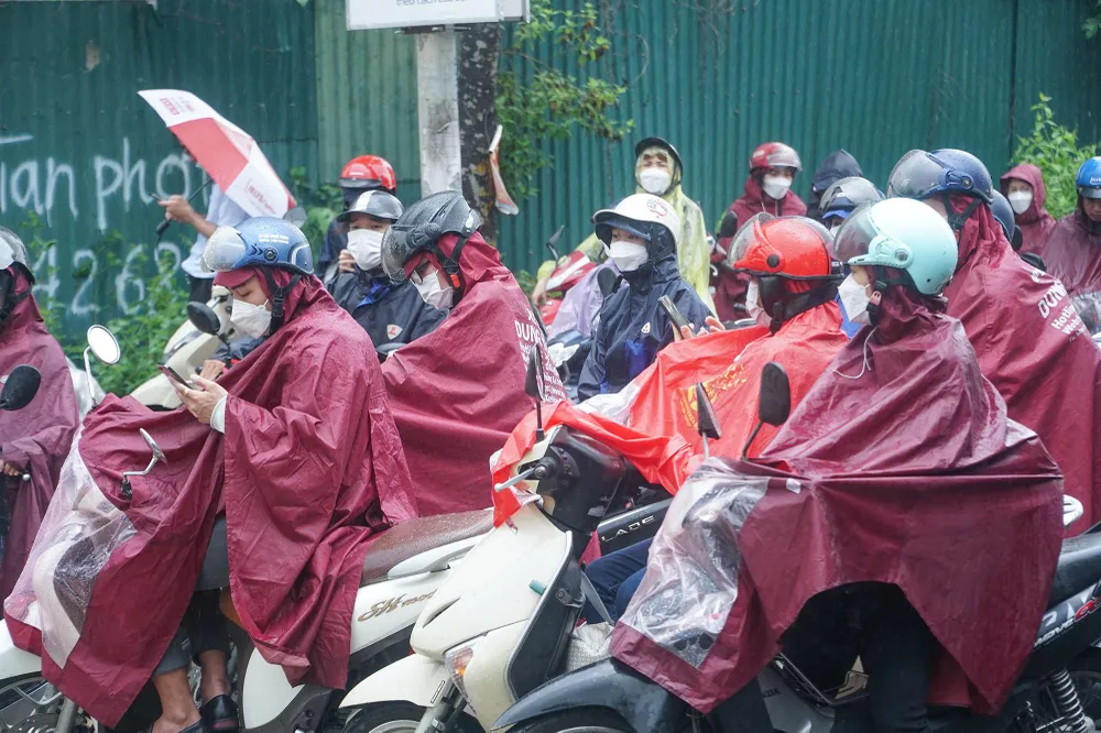 Nhiều người dân phải mặc áo mưa chờ đợi cả giờ đồng hồ trong tình trạng &quot;tiến thoái lưỡng nan&quot;.