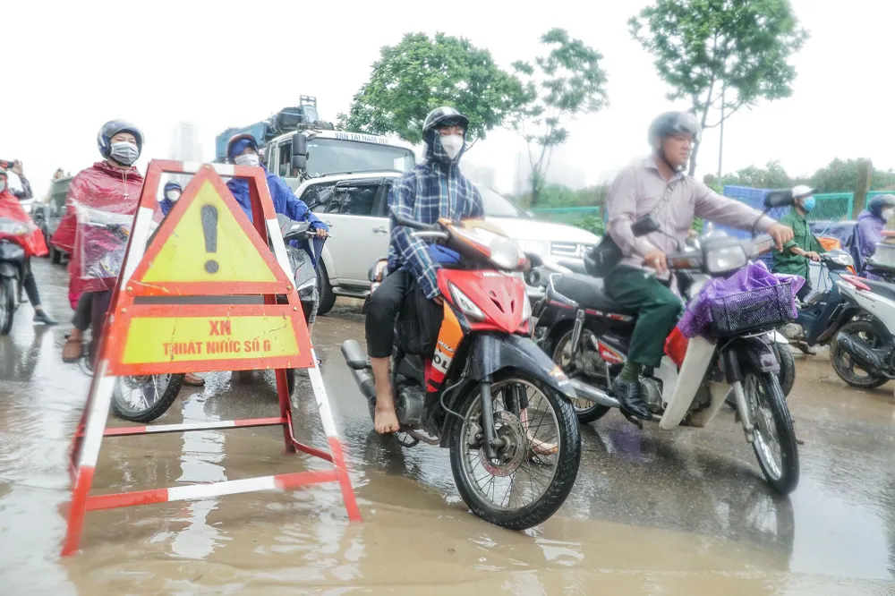 Ghi nhận sáng 23-5 trên đường Đại Lộ Thăng Long, hướng đi cả hai chiều (đoạn qua cổng Thiên đường Bảo Sơn) nước ngập sâu do ảnh hưởng của trận mưa lớn vào rạng sáng cùng ngày.