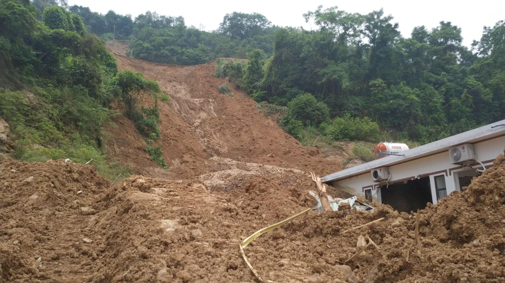 Hiện trường ngổn ngang đất đá, vùi lấp phía sau căn nhà. Ảnh PHI HÙNG
