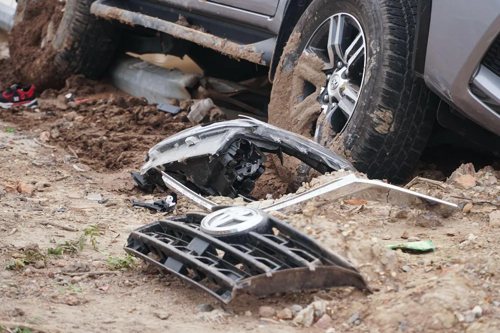 Chiếc Toyota Fortuner bị biến dạng, nằm ở khu vực bãi đất bên ngoài ranh giới đường. Xe Lexus nát đầu, nằm giữa làn khẩn cấp và làn 3 của đại lộ Thăng Long.