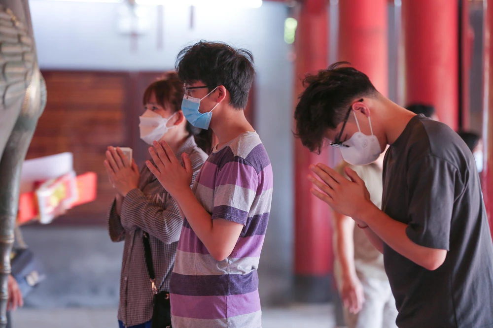 Từng tốp phụ huynh thành kính dâng lễ, thắp hương cầu con em thuận lợi ở kỳ thi quan trọng.Số báo danh, bút mực, thước kẻ, máy tính - những vật dụng thí sinh đưa vào phòng thi được "dâng" lên điện thờ. Nhiều phụ huynh còn mang theo hồ sơ thi của con để đọc rõ ràng số báo danh, phòng thi.