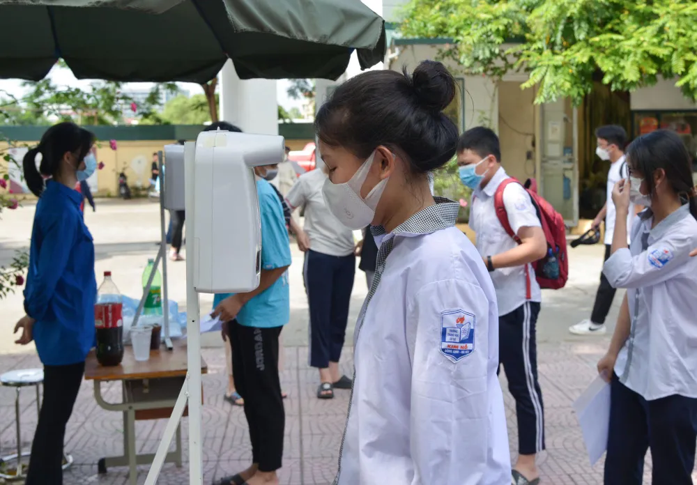 Các thí sinh được yêu cầu đo thân nhiệt, đeo khẩu trang để phòng chống dịch COVID-19.