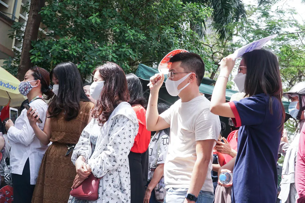 Nhiều người không ngần ngại đứng dưới nắng để chờ đợi con em mình. Nhiều người không ngần ngại đứng dưới nắng để chờ đợi con em mình.