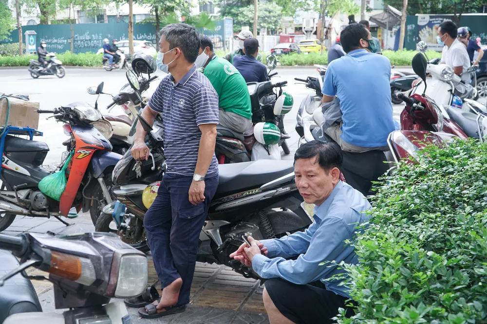 Người đứng người ngồi với vẻ mặt lo lắng. Người đứng người ngồi với vẻ mặt lo lắng.