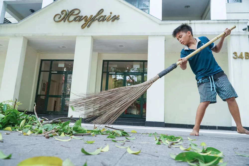 Thu hoạch xong, Huy cẩn thận phụ cha quét dọn trả lại không gian sạch sẽ cho vỉa hè Hà Nội.