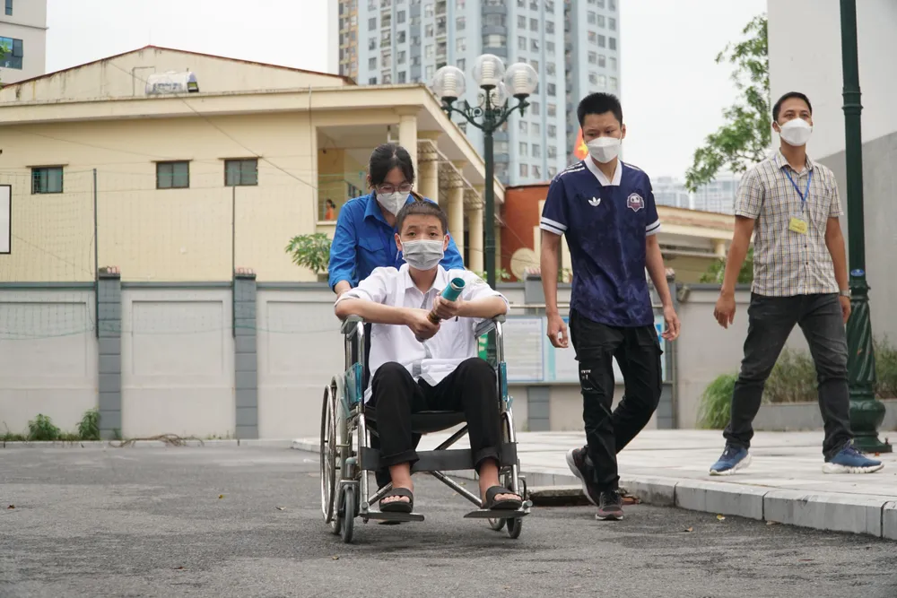 Tình nguyện viên hỗ trợ đưa đón Quyền tại điểm thi. Ảnh PHI HÙNG Tình nguyện viên hỗ trợ đưa đón Quyền tại điểm thi. Ảnh PHI HÙNG