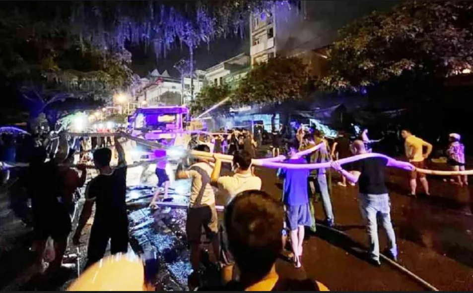 Người dân phối hợp cùng lực lượng Phòng cháy chữa cháy trong vụ cháy tại TP Móng Cái đêm 21-7. Ảnh CTV
