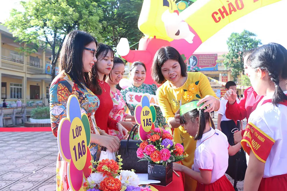 Nhà trường cũng chuẩn bị những chiếc mũ đội đầu nhỏ xinh cùng cờ Tổ quốc để phát cho trẻ. Các cô giáo đã ân cần tiếp đón, hướng dẫn các phụ huynh và trẻ vào ngồi đúng vị trí của lớp ở sân trường.