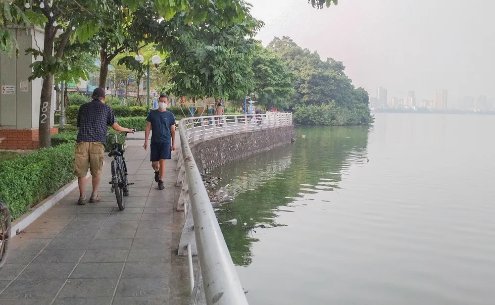 Nhiều người dân khi đi tập thể dục qua khu vực này phải bịt khẩu trang vì mùi tanh hôi từ mặt hồ bốc lên nồng nặc.