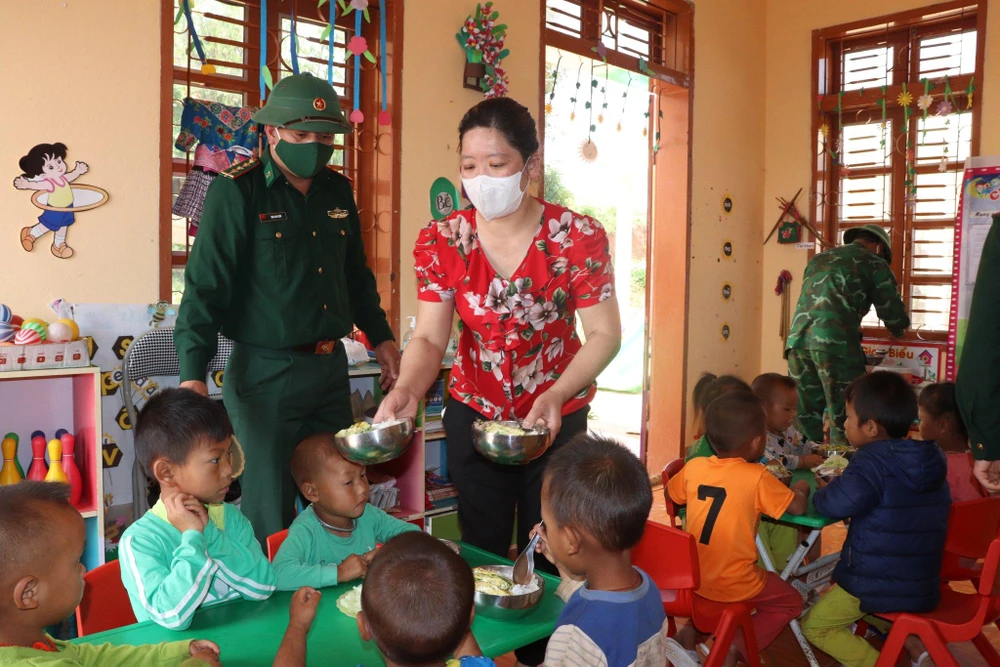 Cô Nguyễn Hương Giang cùng các cán bộ, chiến sĩ đồn biên phòng chuẩn bị cơm cho học sinh. Ảnh LÊ ĐỒNG