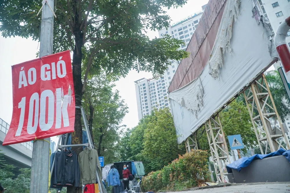 Một tấm biển quảng cáo lớn (tay phải) trên đường Phạm Văn Đồng đã rách nát theo thời gian nhưng không được thu hồi.