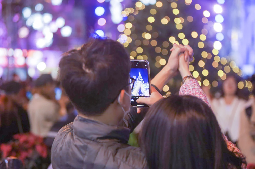 Họ cùng nhau tạo dáng trước cây thông lung linh cao đến hơn chục mét.