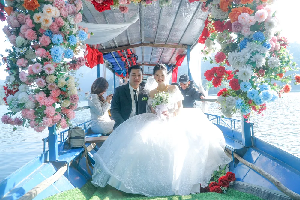 Đôi bạn trẻ Đồng Diệm và Ngọc Ánh hạnh phúc trên chiếc xuồng chạy dọc trên mặt hồ Ba Bể trong ngày lễ thành hôn. Cô dâu cùng chú rể sẽ đi xuồng mất gần một giờ đồng hồ.