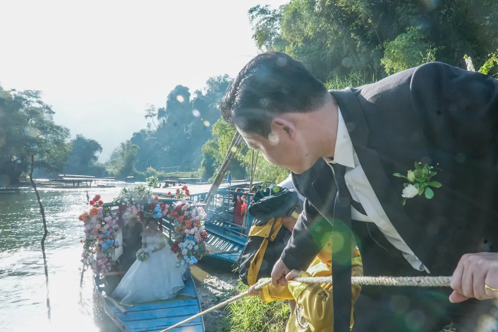 Khoảnh khắc chú rể kéo dây neo đậu xuồng để cô dâu bước lên bờ về nhà chồng. Đây cũng là nét đặc trưng của người dân sống cạnh hồ Ba Bể.