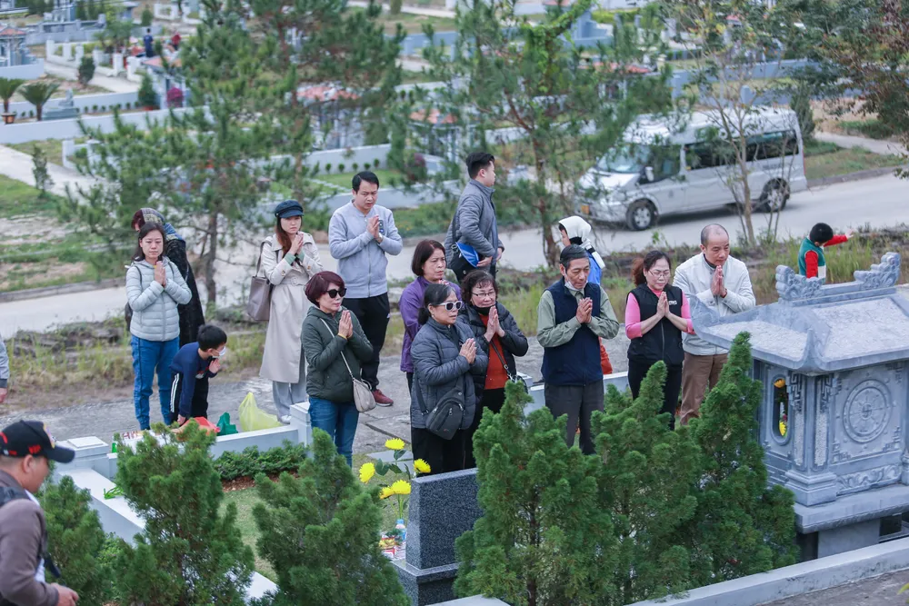 Tại mộ phần gia tiên, đại gia đình ông Dương Đức Minh (70 tuổi, ở quận Ba Đình, Hà Nội) với nhiều thế hệ từ con cháu đến chắt, cùng tề tựu, một lòng thành kính, xúc động tưởng nhớ những người thân trong những ngày cuối năm để mời gia tiên về đón Tết.