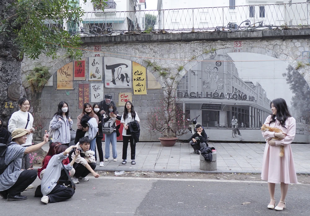 Một nhóm bạn trẻ rủ nhau tới đây để chụp ảnh lưu niệm trên phố bích họa Phùng Hưng.