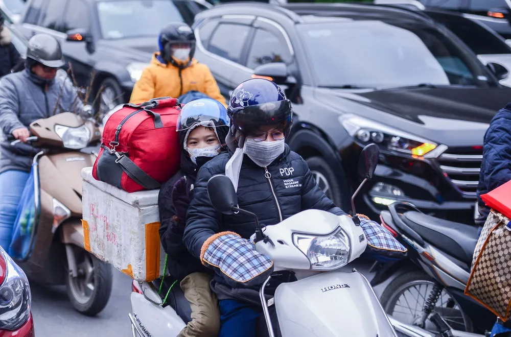 Nhiều người đèo con nhỏ cùng hành lý bằng xe máy để về quê đón Tết Nguyên đán. Nhiều người đèo con nhỏ cùng hành lý bằng xe máy để về quê đón Tết Nguyên đán.