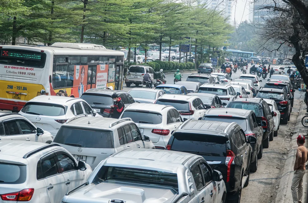 Phía bên ngoài mặt đường Cầu Giấy, đoạn trước cổng trung tâm đăng kiểm, hàng trăm xe ô tô nối đuôi nhau xếp thành 2 - 3 hàng.