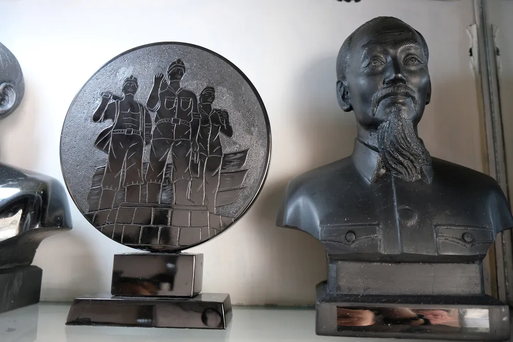 Chân dung Chủ tịch Hồ Chí Minh được nghệ nhân điêu khắc từ than đá, đặt trang trọng trong tủ kính phòng khách tại gia đình.