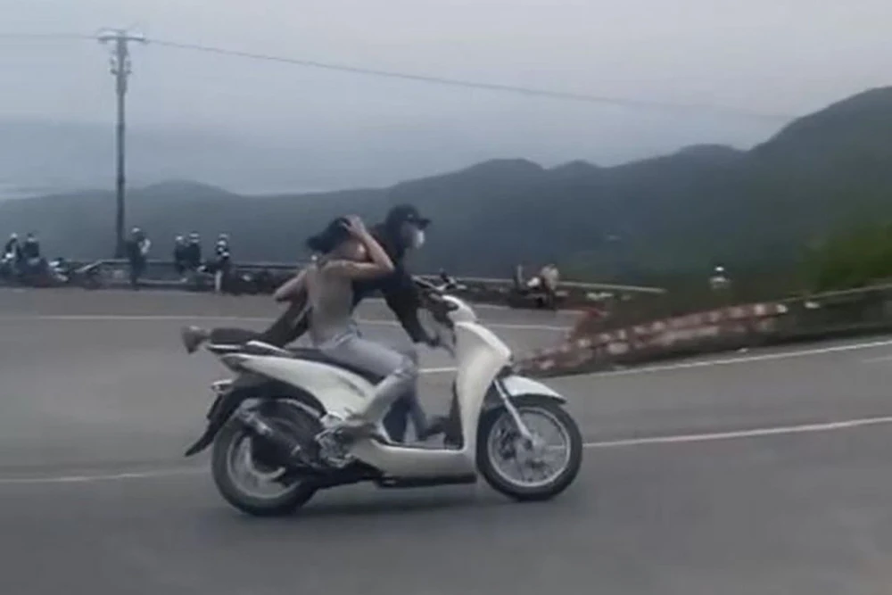 Cặp vợ chồng "diễn xiếc" ở đèo Hải Vân. Ảnh: Cắt từ clip