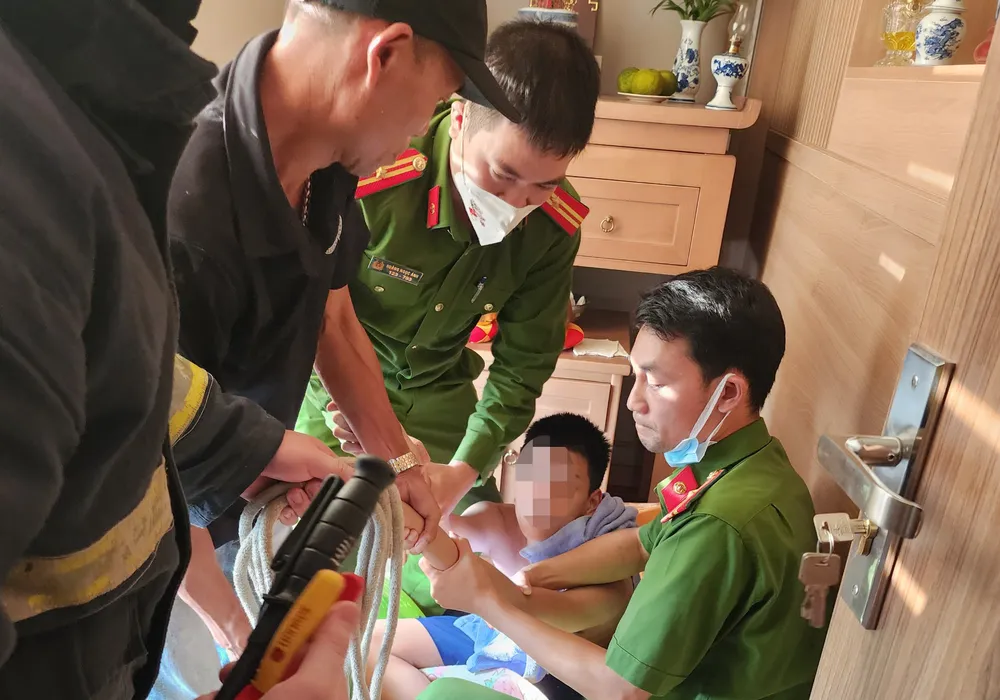 Thời điểm bé trai được lực lượng chức năng giải cứu. Ảnh CA