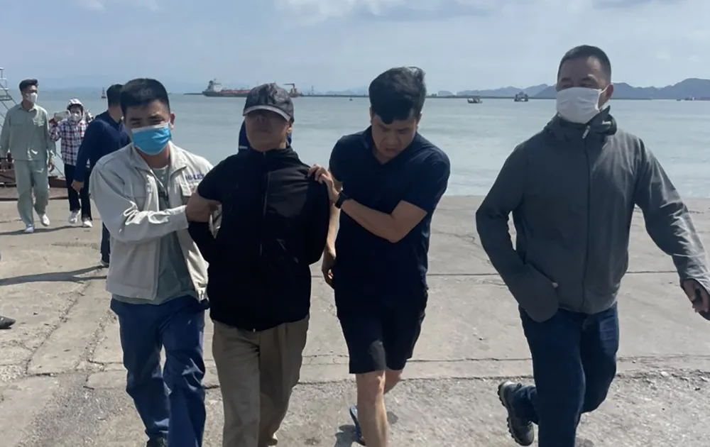 Ông Lê Văn Nghị (đội nón) được lực lượng chức năng đưa về trụ sở công an. Ảnh: CA