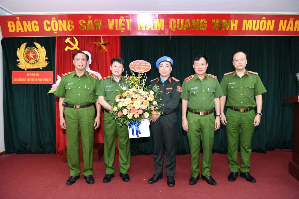 Đảng uỷ và lãnh đạo Cục Cảnh sát điều tra tội phạm về ma tuý tặng hoa chúc mừng Trung tá Bùi Phương Lân. Ảnh BCA