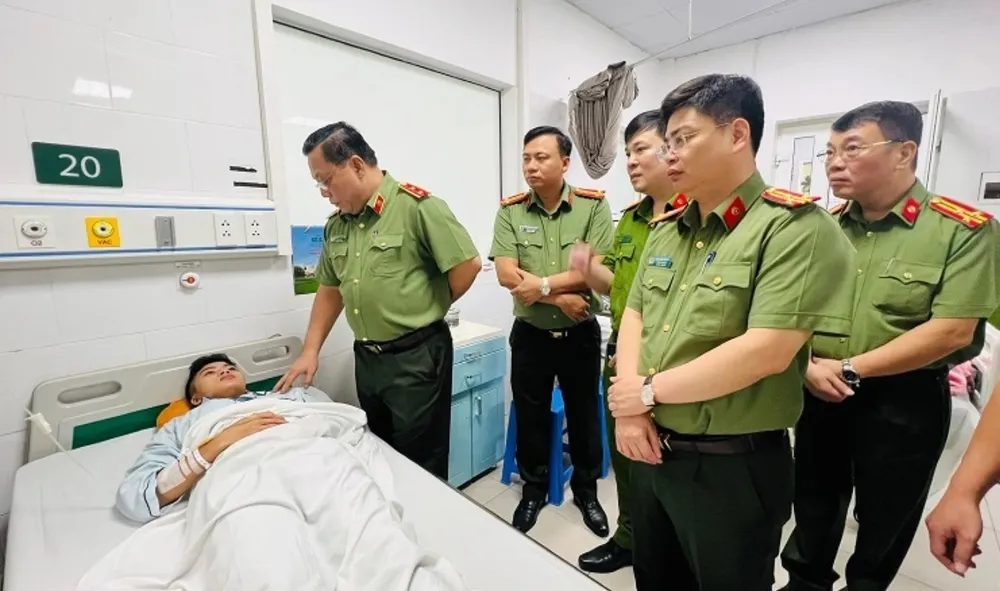 Lãnh đạo Công an Hà Nội hỏi cán bộ công an bị thương khi làm nhiệm vụ. Ảnh CA Screenshot 2023-09-17 183354.jpg