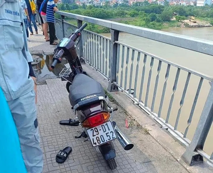 Chiếc xe máy và đôi dép của nam thanh niên nghi nhảy cầu. Ảnh: CTV Hà Nội: Tìm kiếm nam thanh niên nghi nhảy cầu Đông Trù