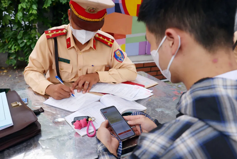 CSGT xử lý, tạm giữ GPLX người vi phạm giao thông trên ứng dụng VNeID.Ảnh PHI HÙNG z5617524665654_149d38e322bdbe7640f193ed64bfb870.jpg