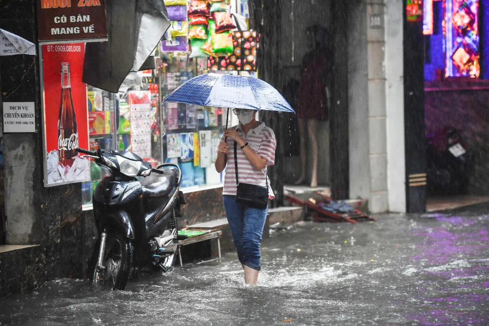 Người dân vất vả khi di chuyển qua đây. Ảnh hưởng bão số 2, nhiều tuyến phố ở Hà Nội ngập sâu