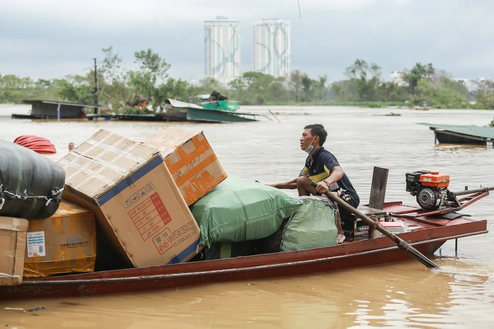 Báo động I là tình huống sông bắt đầu có lũ, nhưng còn ở giới hạn trong lòng sông - tương đương cấp lũ nhỏ. Dù vậy, khu vực nội đô, các hộ dân sinh sống ở bãi giữa sông Hồng, thuộc phường Chương Dương, quận Hoàn Kiếm, nước đã tràn vào nhà. Với dự báo nước còn lên, nhiều gia đình khác đã hò nhau đóng gói tài sản, chuyển lên nơi cao hơn. Trong ảnh, bà con dùng thuyền sắt chuyển đồ đạc đã đóng gói từ bãi giữa vào bờ.