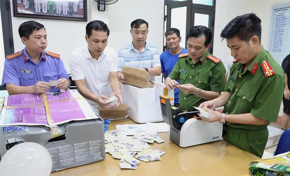 Lực lượng chức năng kiểm đếm tang vật vụ án. Ảnh: CA đại tá trần quốc huy, phó giám đốc công an tỉnh cùng các lực lượng chức năng kiểm tra số giấy tờ các đối tượng làm giả.jpg