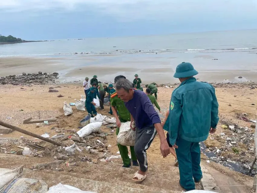 Chính quyền cùng người dân Nghệ An gia cố đê biển, kè chắn sóng bằng bao cát, bao tải để chống bão số 5. Ảnh: THU THỦY