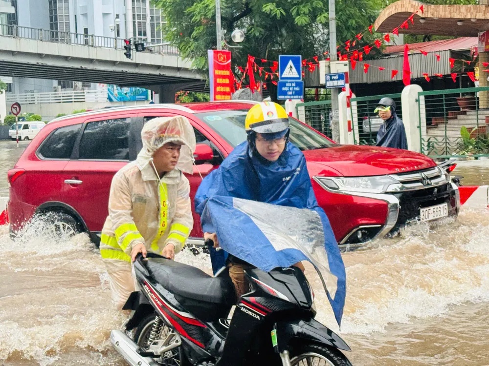 CSGT hỗ trợ người dân qua điểm ngập úng. Ảnh: CA