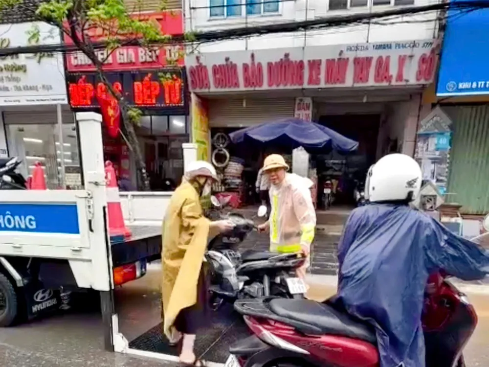 CSGT Hà Nội sử dụng xe chuyên dụng hỗ trợ đưa phương tiện của người dân qua điểm ngập sâu. Ảnh: CA