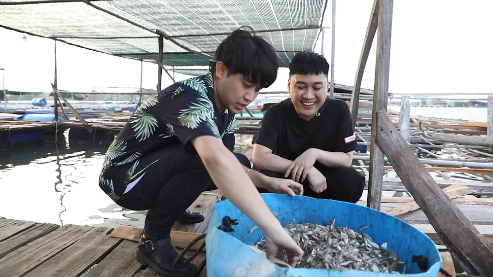 Cả hai nhân vật cho cá ăn.