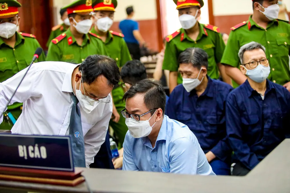 Bị cáo Tề Trí Dũng trao đổi với luật sư trong giờ giải lao.