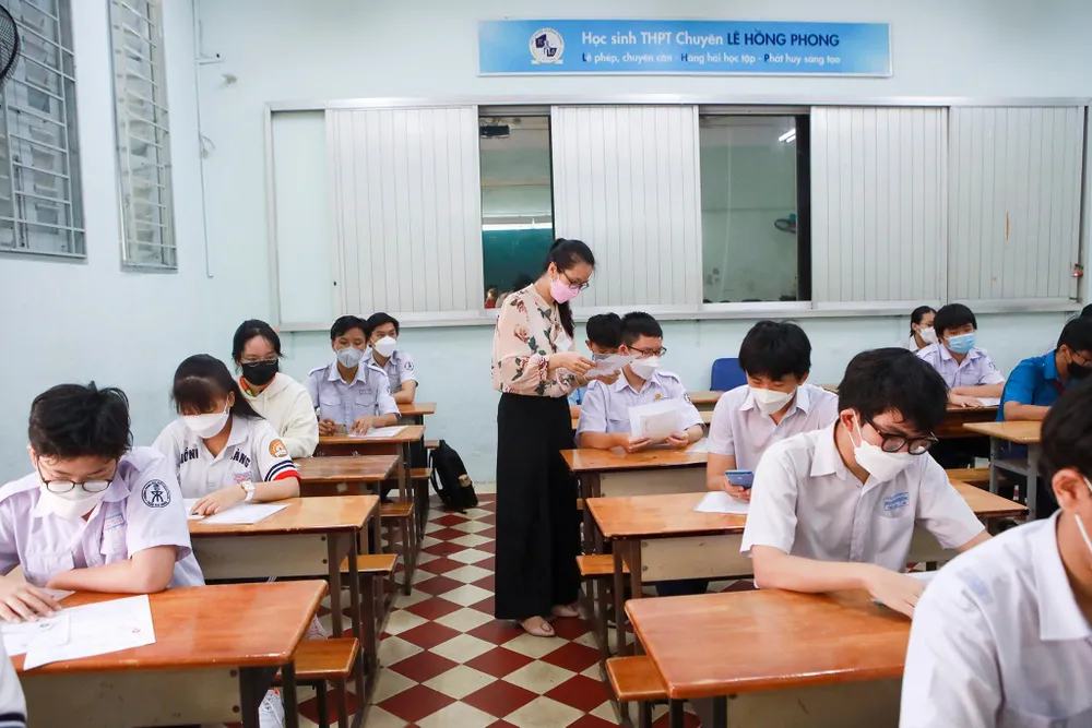 Cán bộ coi thi kiểm tra giấy tờ cho các em học sinh.